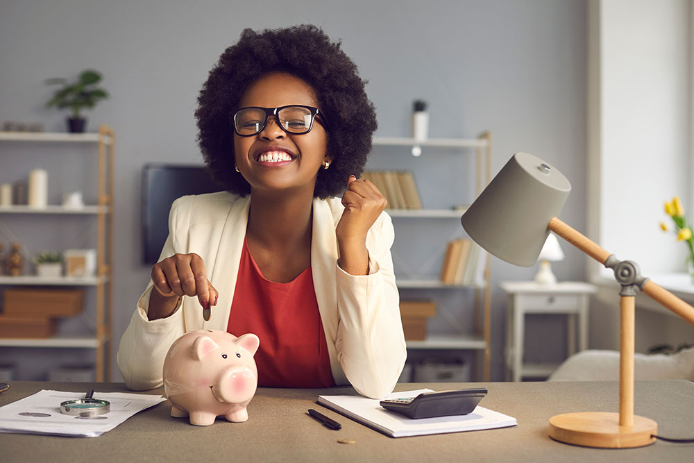 Excited woman in eyewear putting coin into piggybank