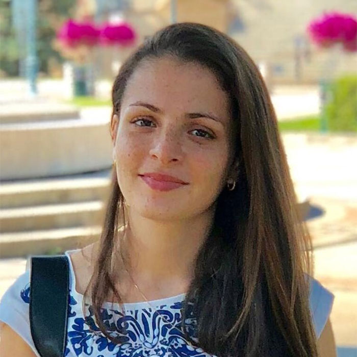 Ana Antunes smiling with flowers in background