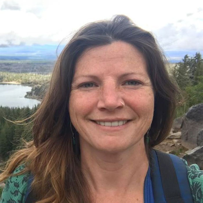 Barb Wilton smiling with forest in the background