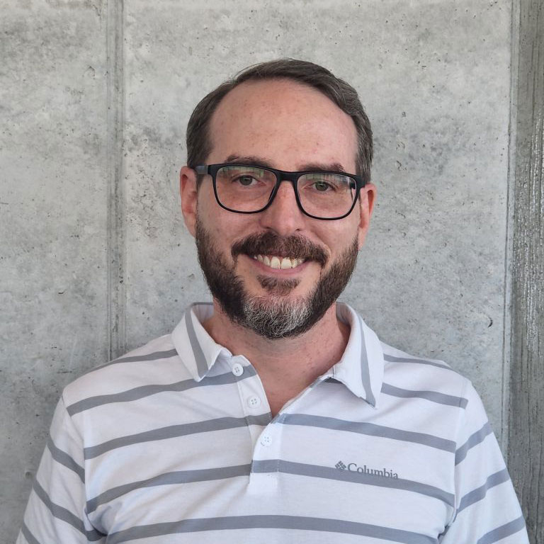 Jeff Patteson smiling in front of wall