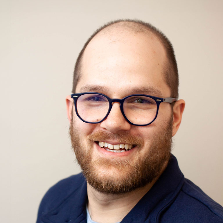 Close-cut of Kevin Schachter smiling, wearing eyeglasses