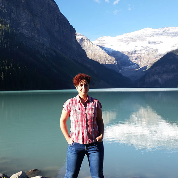 Leyla Shahsavar standing in front of mountains and lake