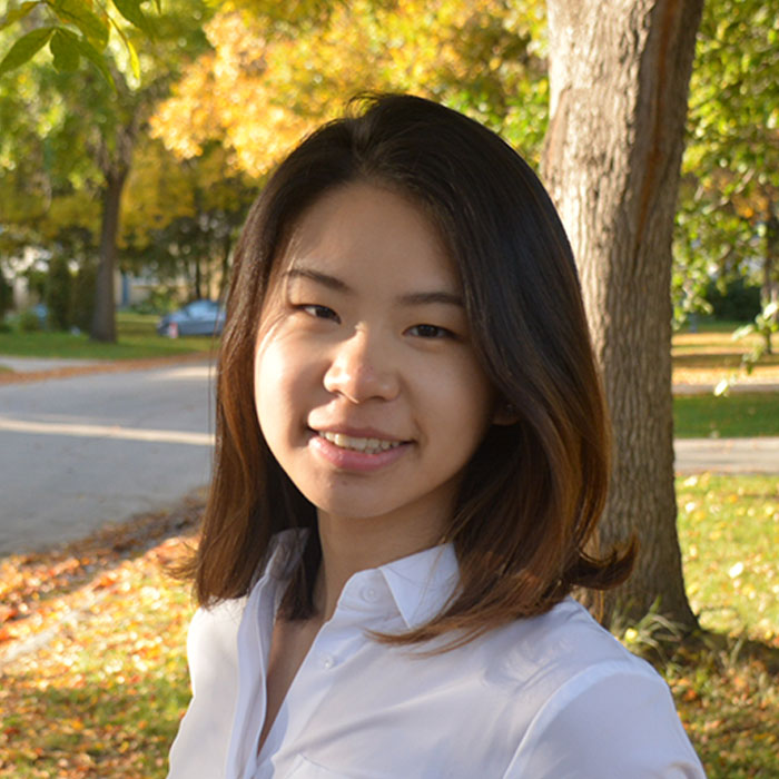 Qiuyi Kate Zha smiling in front of backdrop of trees