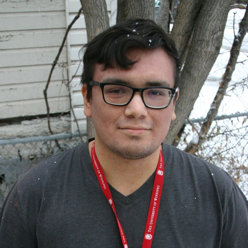 Andrew Proulx-Courchene wearing eyeglasses with snow and a tree in the background